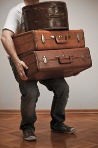 man_with_heavy_load_of_old_suitcases